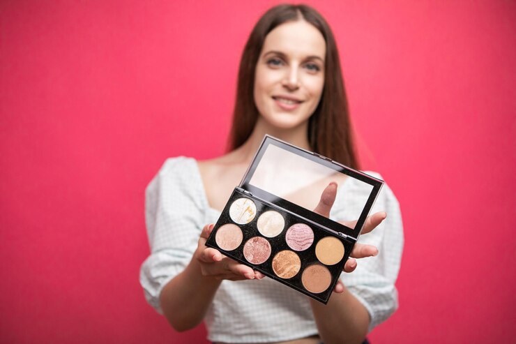 Mujer sostenga paleta de maquillaje en las manos.