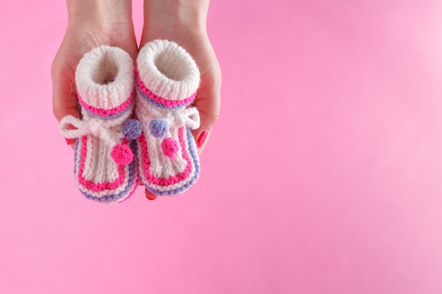 Mujer sostenga pequeños botines recién nacidos