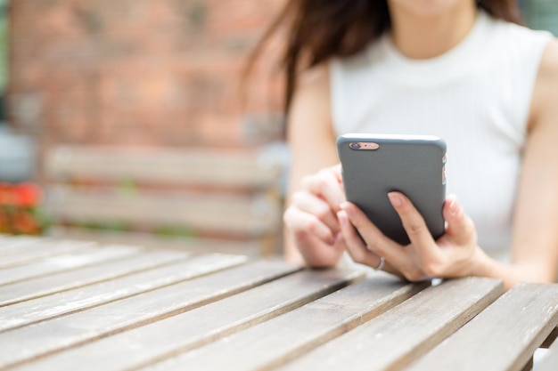 Mujer sostenga con teléfono inteligente en la cafetería