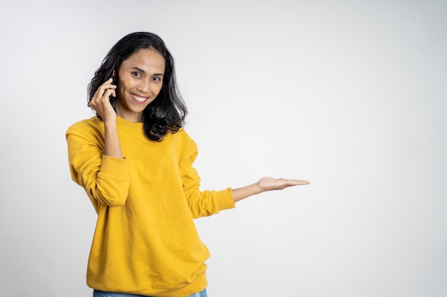 Mujer sostenga un teléfono móvil con gesto de la mano presentando