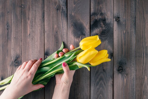 Mujer sostenga tulipanes amarillos