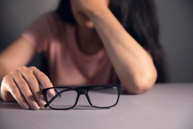 Una mujer sosteniendo anteojos