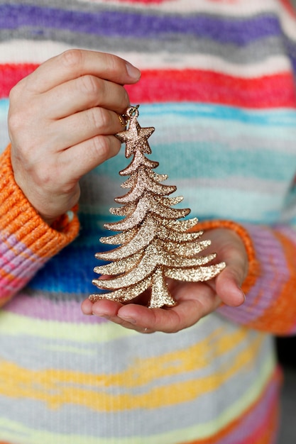 Foto mujer sosteniendo un árbol de navidad decorativo