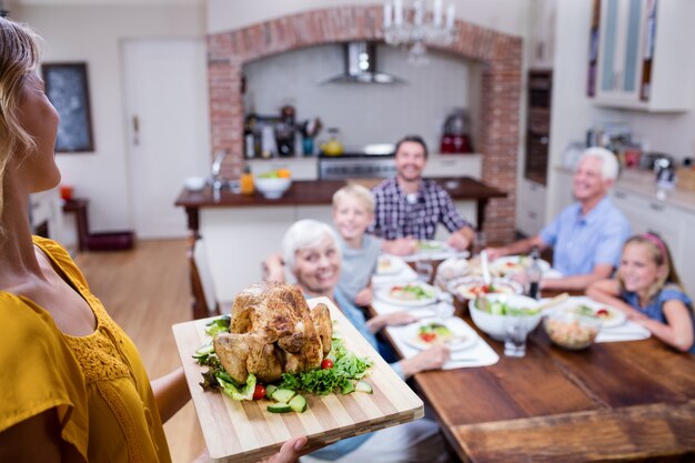 Mujer sosteniendo una bandeja de pavo asado