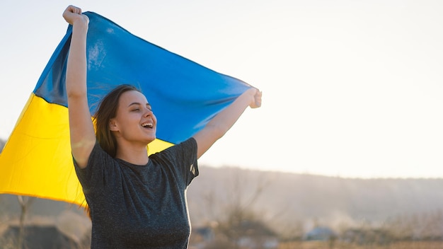 Mujer sosteniendo una bandera amarilla y azul de ucrania al aire libre