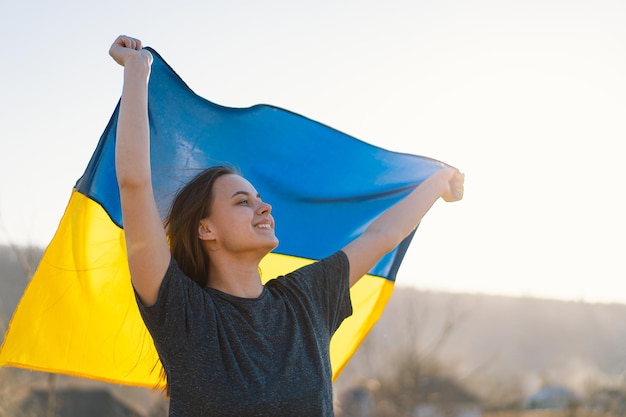 Mujer sosteniendo una bandera amarilla y azul de ucrania al aire libre