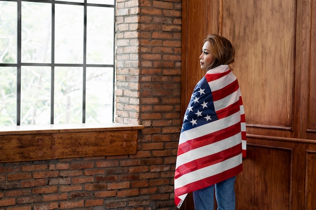 Foto mujer sosteniendo la bandera americana