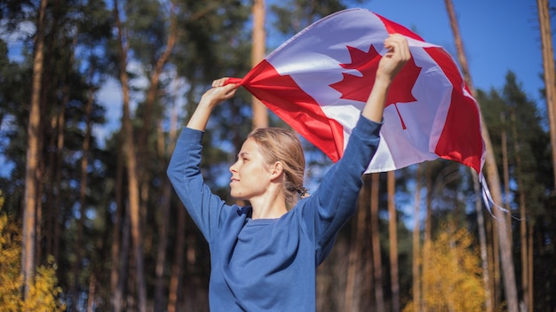 Foto mujer sosteniendo la bandera de canadá. fiesta nacional canadiense. 1 julio.