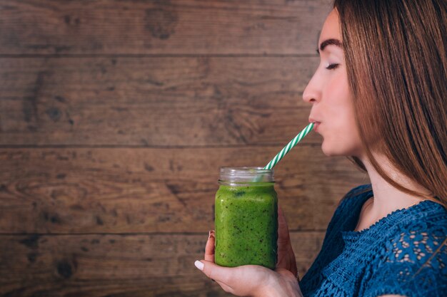 Mujer sosteniendo batido de kiwi