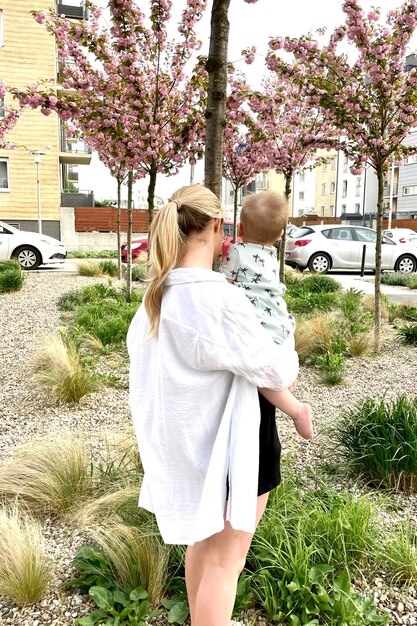 una mujer sosteniendo un bebé y un árbol con un letrero que dice "cuota de primavera"