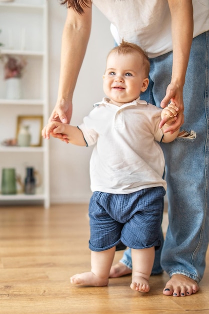 Mujer sosteniendo a los bebés con la mano en el suelo de madera