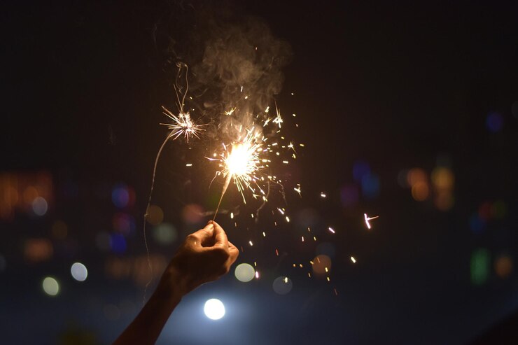 Mujer sosteniendo una bengala fuera de Diwali fiesta de Navidad de Año Nuevo o celebración de cumpleaños