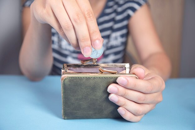 Mujer sosteniendo billetera con monedas