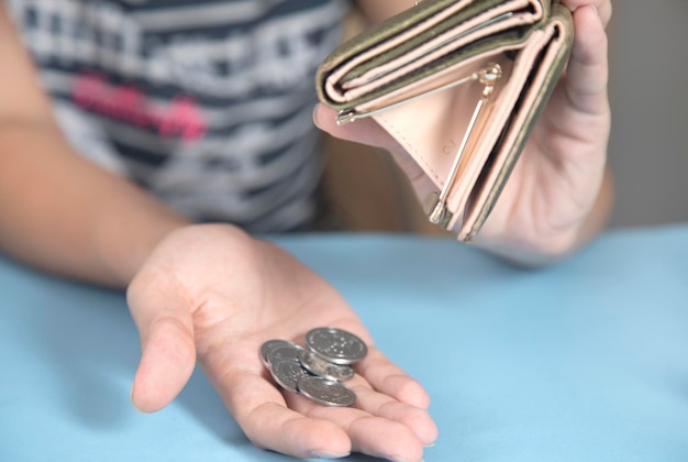 Mujer sosteniendo billetera y monedas