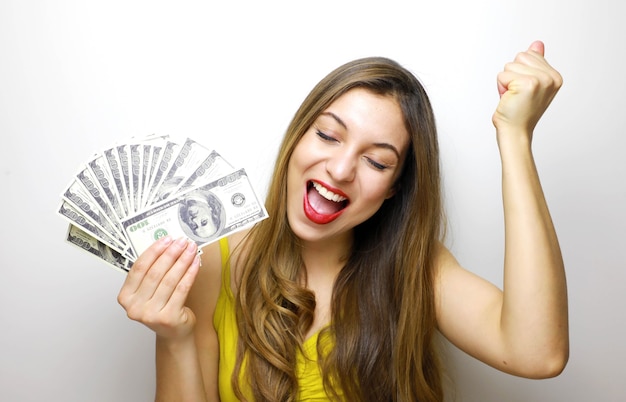 Mujer sosteniendo billetes de dinero y celebrando