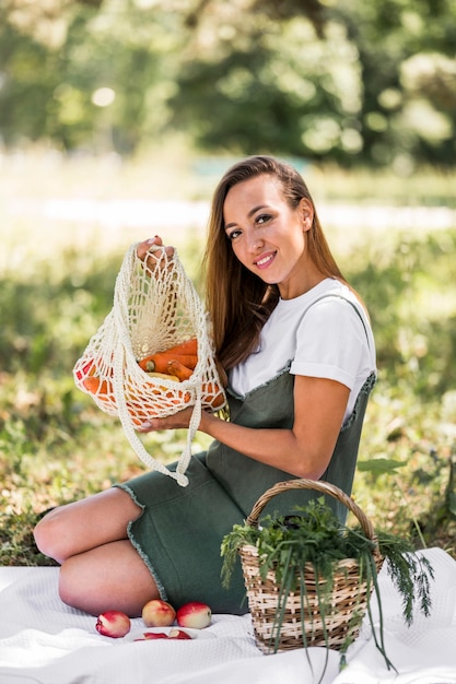 Mujer sosteniendo una bolsa con bocadillos saludables