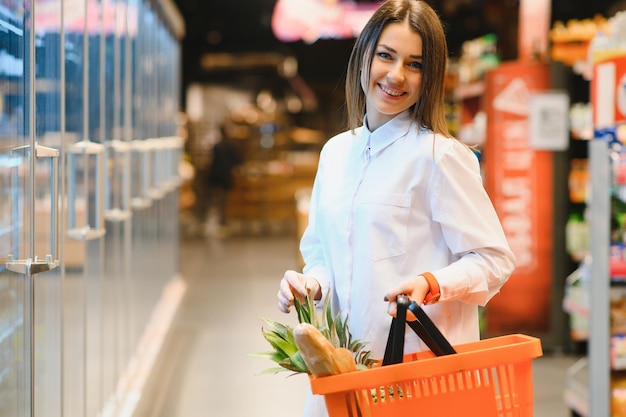 Mujer sosteniendo una bolsa de compras de alimentos frescos