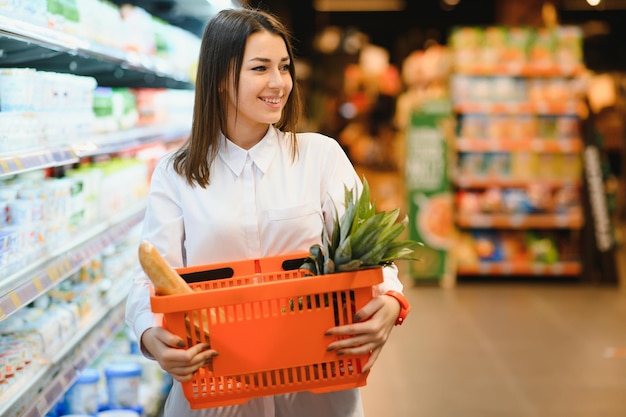 Mujer sosteniendo una bolsa de compras de alimentos frescos