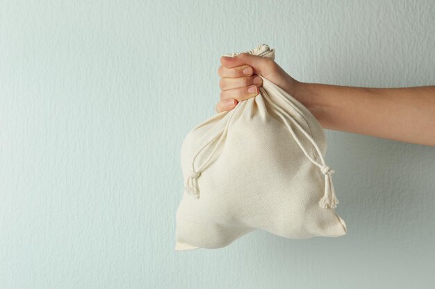 Foto mujer sosteniendo una bolsa ecológica de algodón llena en primer plano de fondo claro