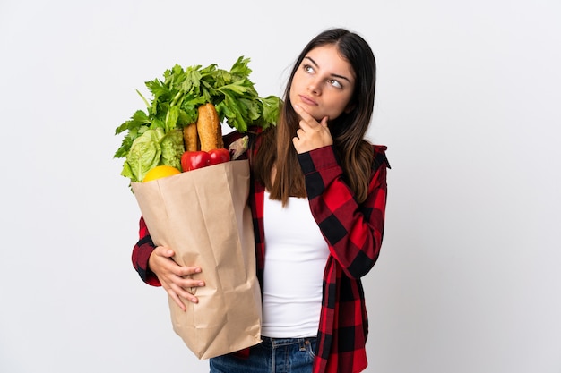 Mujer sosteniendo una bolsa llena de verduras