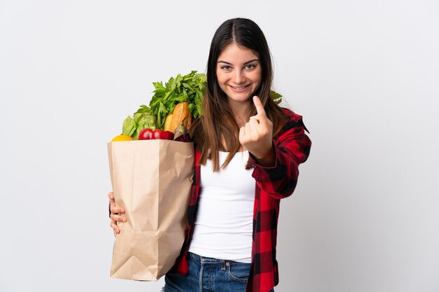 Mujer sosteniendo una bolsa llena de verduras