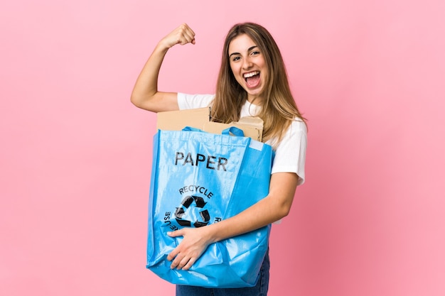 Mujer sosteniendo una bolsa de reciclaje llena de papel