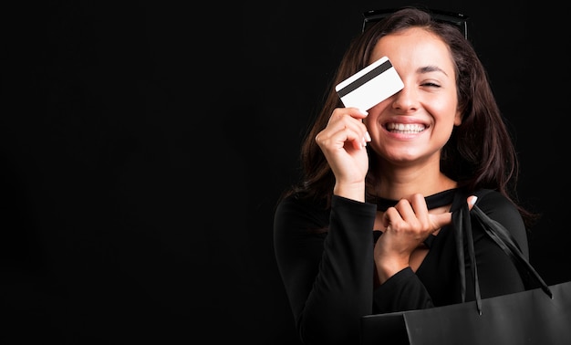 Mujer sosteniendo bolsa y tarjeta de crédito