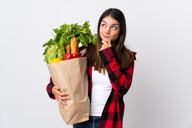 Mujer sosteniendo una bolsa con verduras