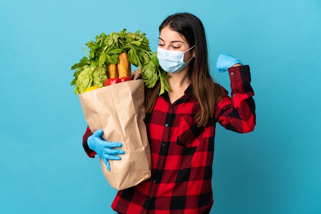 Mujer sosteniendo una bolsa con verduras