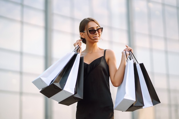 Foto mujer sosteniendo bolsas de la compra en la calle