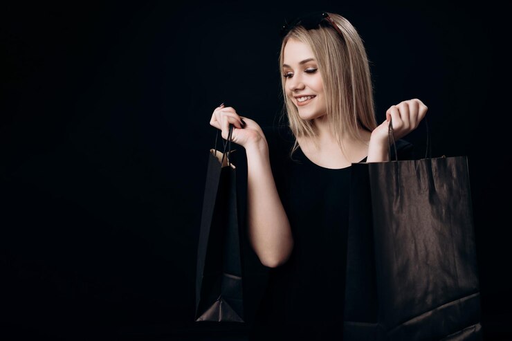 Mujer sosteniendo bolsas de compras en dos manos