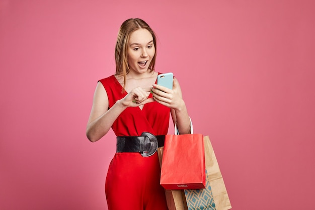 mujer sosteniendo bolsas de compras usando aplicaciones móviles para compras en línea Concepto de descuentos en centros comerciales de venta