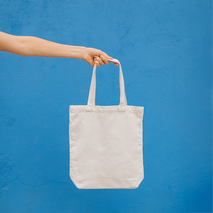 Foto mujer sosteniendo bolso de lona sobre fondo azul brillante en la ciudad. bolsa ecológica reutilizable. concepto ecológico.
