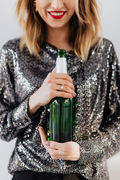 Mujer sosteniendo una botella de champagne