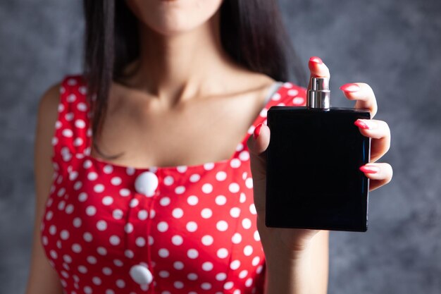 Mujer sosteniendo una botella de perfume