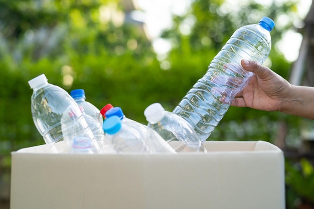 Mujer sosteniendo botellas de plástico basura en caja para reutilizar reciclar para un buen ambiente