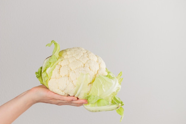 Mujer sosteniendo una cabeza de coliflor