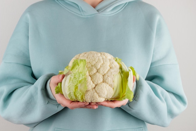 Foto mujer sosteniendo una cabeza de coliflor