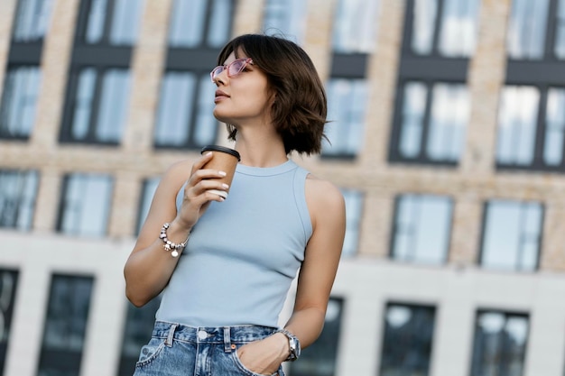 Mujer sosteniendo café en vaso de papel