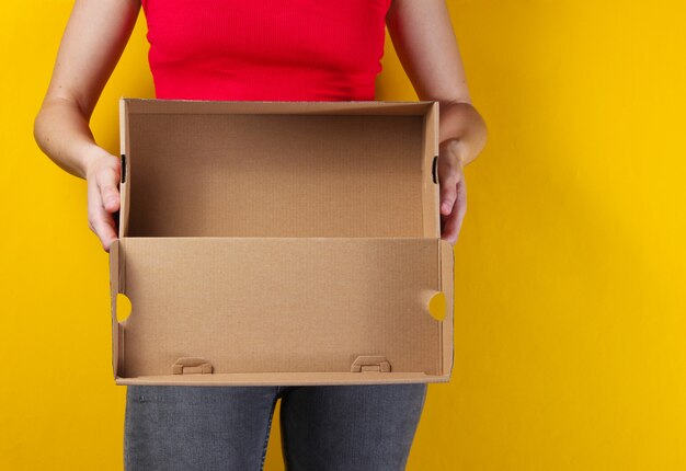 Mujer sosteniendo una caja de cartón vacía