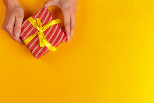 Mujer sosteniendo caja de regalo en amarillo