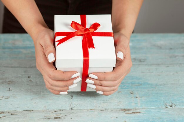 Mujer sosteniendo caja de regalo blanca