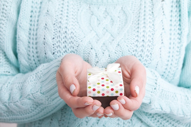 Mujer sosteniendo caja de regalo con cinta