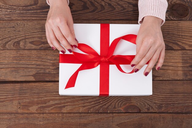 Mujer sosteniendo caja de regalo con cinta