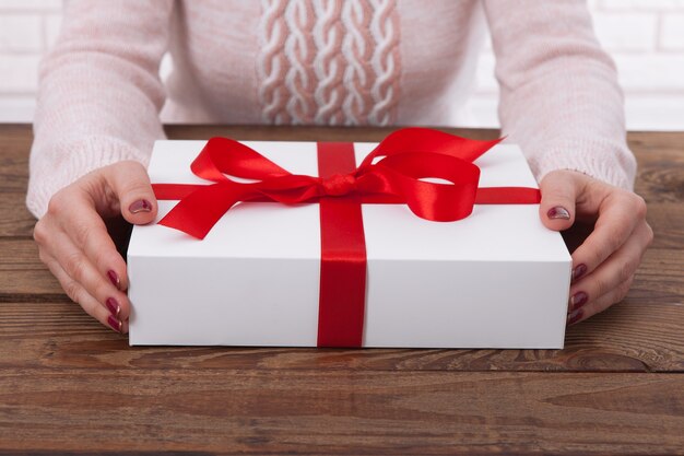 Mujer sosteniendo caja de regalo con cinta