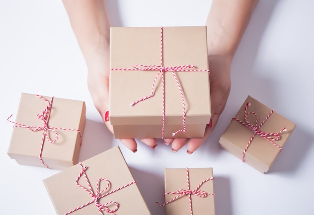 Mujer sosteniendo una caja de regalo de Navidad en una mano