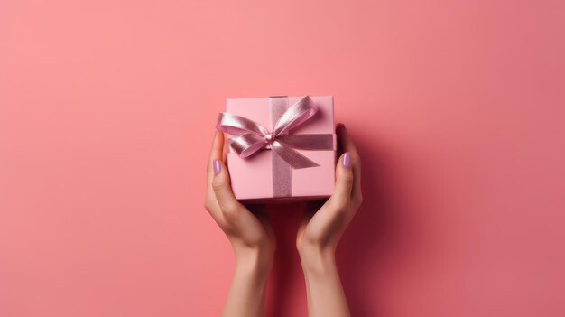 Una mujer sosteniendo una caja de regalo rosa con una cinta rosa.