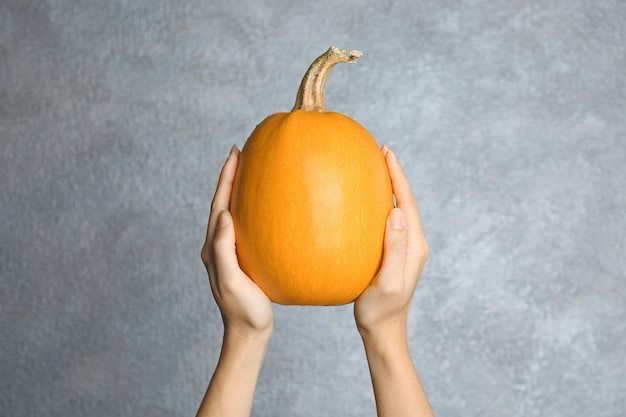 Mujer sosteniendo calabaza espagueti madura sobre fondo claro