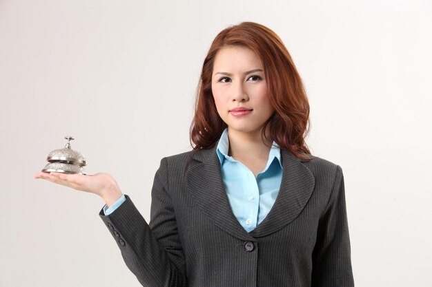 Mujer sosteniendo una campana de escritorio