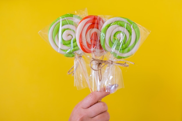 Una mujer sosteniendo un caramelo de colores en la mano.